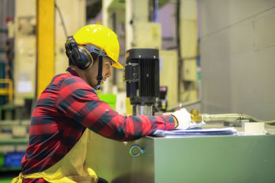 Side view of man working in factory