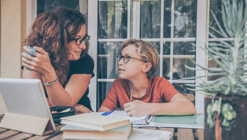 Young student do homework at home with his mother. education and new tech lifestyle concept.