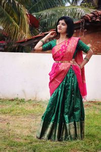 Portrait of young woman standing on field