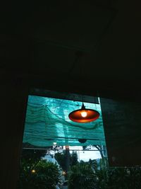 Low angle view of illuminated lighting equipment hanging on wall