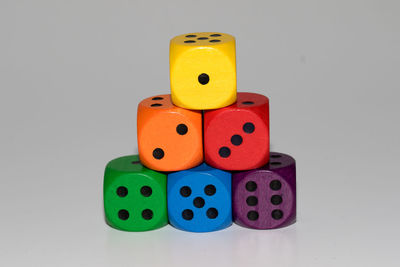 Multi colored dice arranged on white background