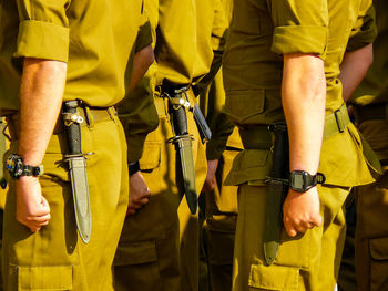 Midsection of army soldiers standing outdoors