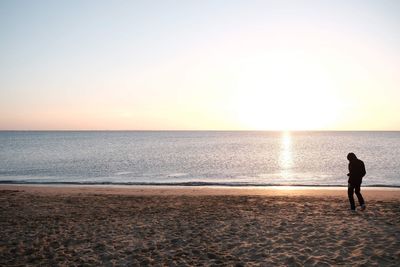 Silhouette of woman looking at sea against sky