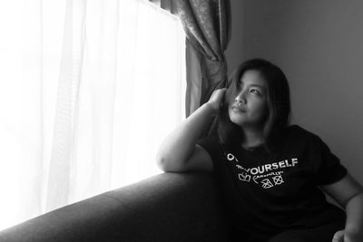 Portrait of a smiling young woman sitting at home