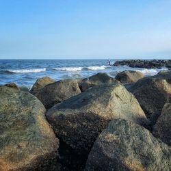 Rocks on beach against clear sky