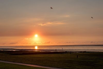 Scenic view of beach against sky during sunset