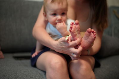 Mother holding sweet little boy with his feet in foreground