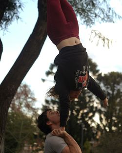 Young woman doing acrobats with man at park