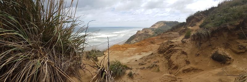 Mountain by beach against sky