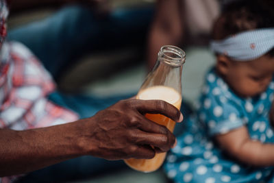 Midsection of man drinking glass bottle