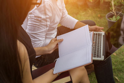 High angle view of woman holding paper outdoors