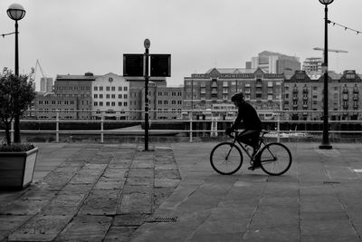 Side view of man riding bicycle in city