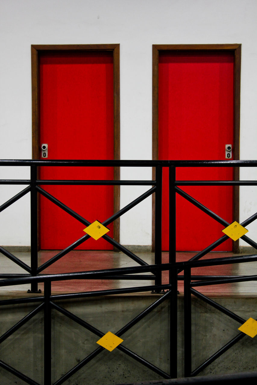 CLOSE-UP OF RED RAILING AGAINST WALL