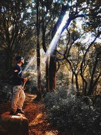 Man standing by trees in forest