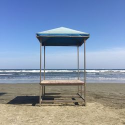 Lifeguard hut on beach against clear sky