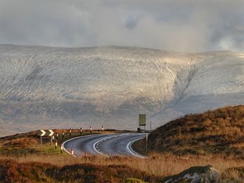 Road by landscape against sky