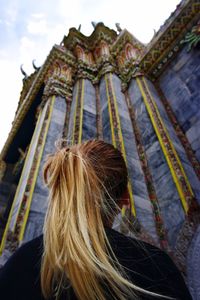 Rear view of woman walking against built structure