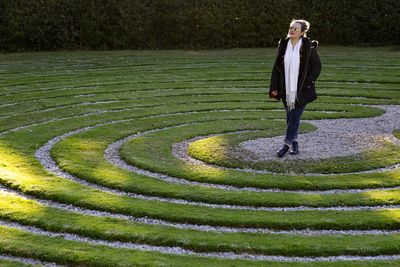 Woman standing amidst bush maze