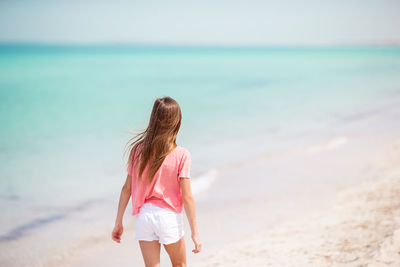 Rear view of girl standing on beach