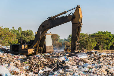 Bulldozer on garbage against sky