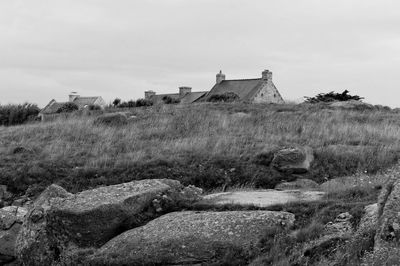 Old house on field against sky