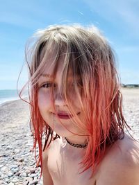 Portrait of woman at beach against sky