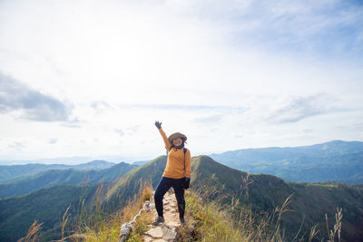 Full length of man standing on mountain against sky