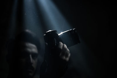 Man holding camera in darkroom