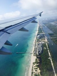 Cropped image of airplane flying over calm sea