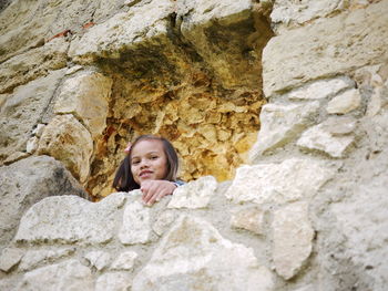 Portrait of smiling girl looking through rocks