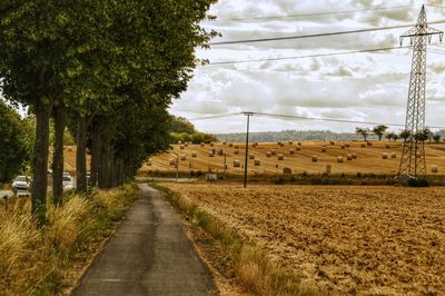 Road amidst field against sky