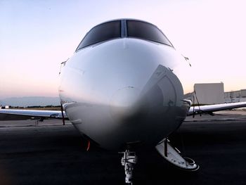 Close-up of airplane on airport runway against clear sky