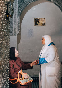 Rear view of man and woman standing against building