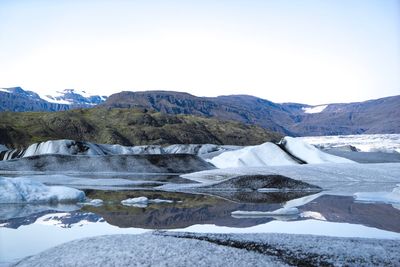 Scenic view of lake by mountains against sky