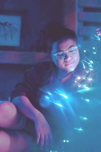 Close-up of young woman in illuminated eyeglasses