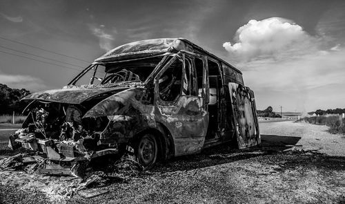 Abandoned car against sky