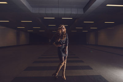 Full length of woman standing in underground walkway