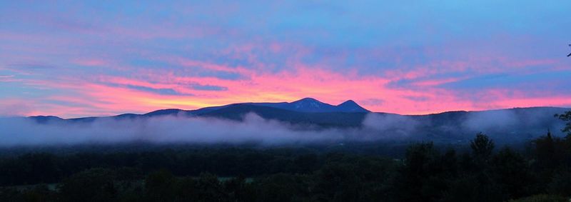 Scenic view of silhouette mountains against sky during sunset