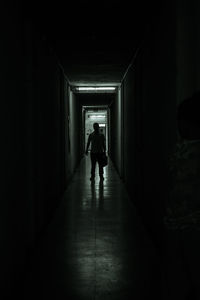 Rear view of man walking in tunnel