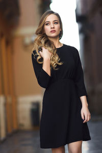 Young woman looking away while walking on street