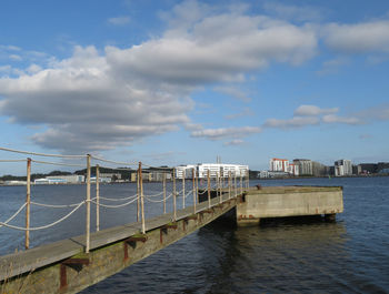 Bridge over sea against sky in city