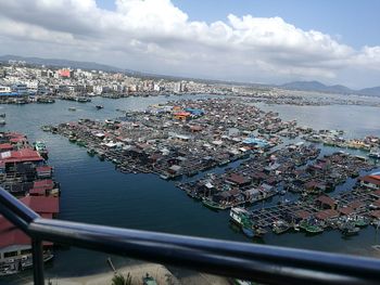 Aerial view of city by sea against sky