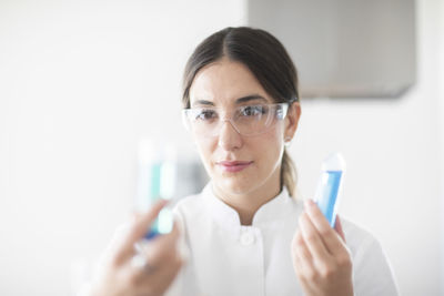 Scientist female with lab glasses, tablet and sample in a lab