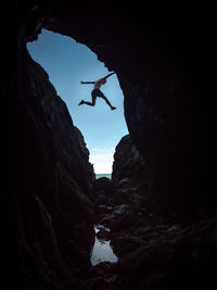 Silhouette man standing on rock formation