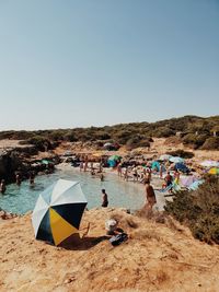 People on beach against clear sky