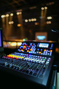 Low angle view of illuminated lighting equipment at night