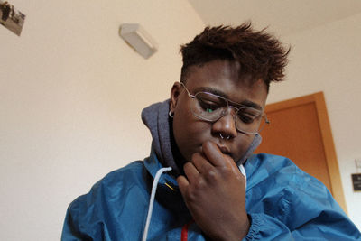 Portrait of mature man sitting against wall at home