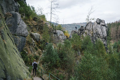 People walking on rocks against sky