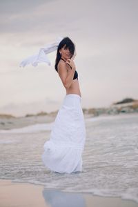 Side view of young woman standing on beach