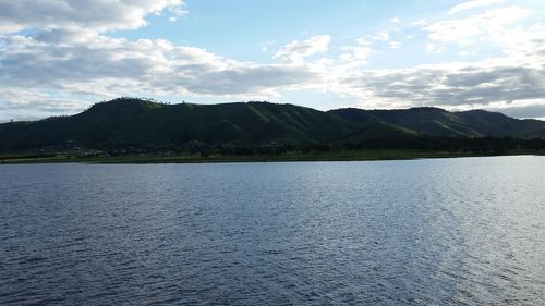 Scenic view of lake by mountains against sky